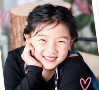 Kylie smiling with her chin on her hands